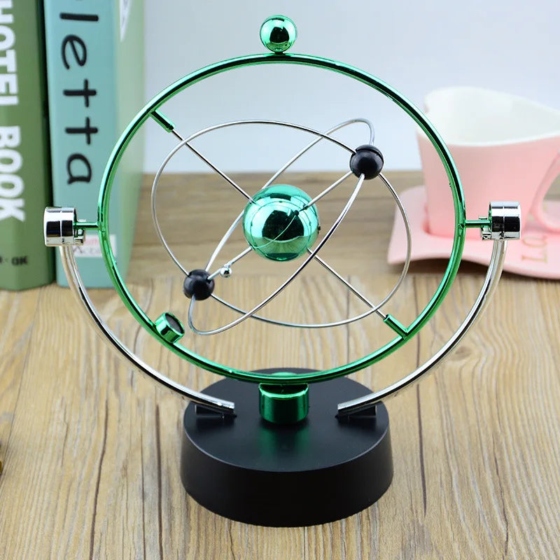 Orbital model on a wooden surface with books and a mug in the background