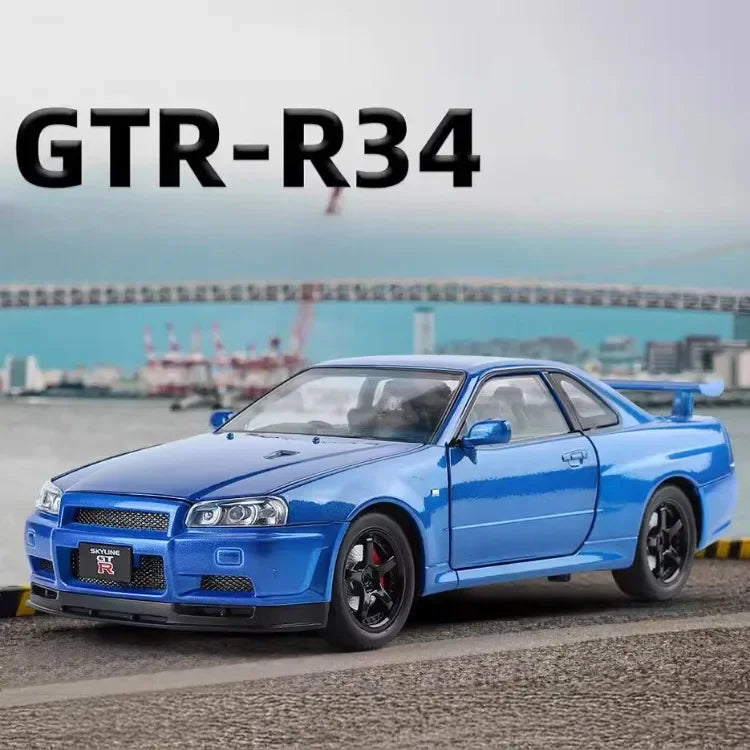 A blue Nissan GTR-R34 sports car shown from a front three-quarter angle on an outdoor road with a blurred harbor and bridge background. Large black text reading 'GTR-R34' appears at the top left.